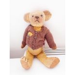 Vintage mohair teddy with glass eyes with a 1902 coronation medal pinned to his brown cardigan