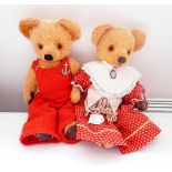 Plush vintage bear wearing knitted dungarees and another in a dirndl style dress with a pendant,