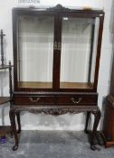Chippendale-style mahogany display cabinet with glazed sides and panel doors,