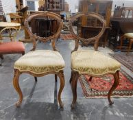 Pair of Victorian carved walnut balloon-back chairs with foliate decoration,