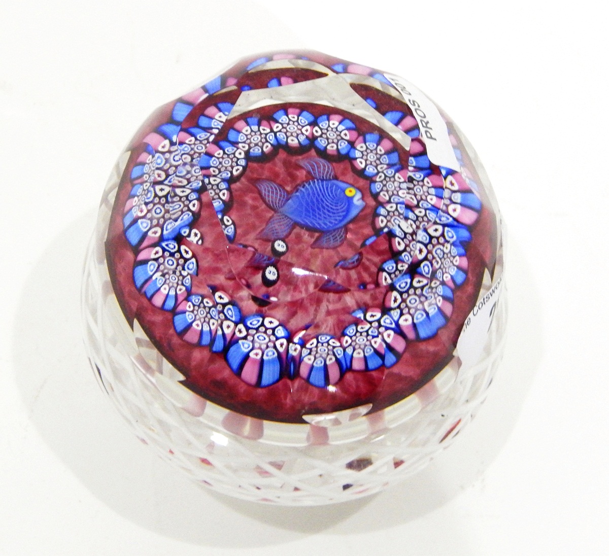 Glass paperweight by John Deacons of faceted circular form with central lampwork and latticino cane