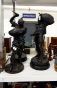 Pair of spelter figures of classical warriors, black painted, on turned wooden plinths,