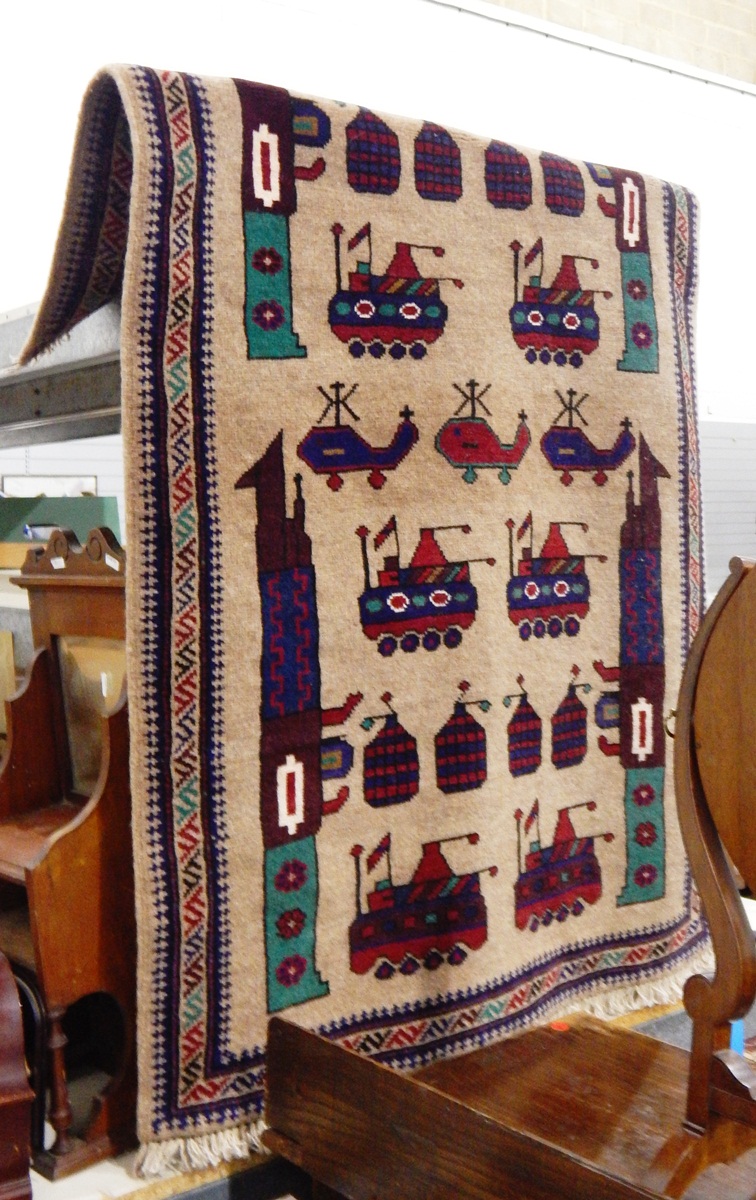 Handmade Eastern wool rug with beige ground, geometric military motifs including tanks, helicopters,