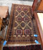 Handmade Eastern wool rug with dark ground with maroon guls, geometric tree detailing,