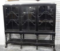 Jacobean-style ebonised glazed bookcase, the three glazed doors enclosing shelves,