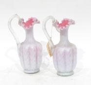 Pair of Stevens & Williams pink and white satin glass ewers, each lobed and having frilled rim,