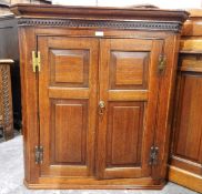 George III oak corner cupboard with dentil frieze,