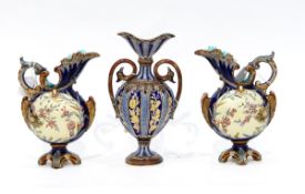 Pair of Wilhelm Schiller majolica jugs with shell moulded spouts and applied cherub floral