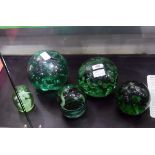 Green glass dump doorstop of spherical form with internal bubble decoration, 14cm high,