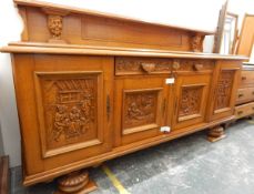 Large early 20th century oak sideboard, the backboard with carved mask decoration,