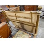 Old brass bedstead raised on castors, with bed irons,