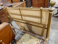 Old brass bedstead raised on castors, with bed irons,