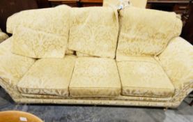 Two-seater settee with loose squab cushions, upholstered in a gold-coloured fabric,
