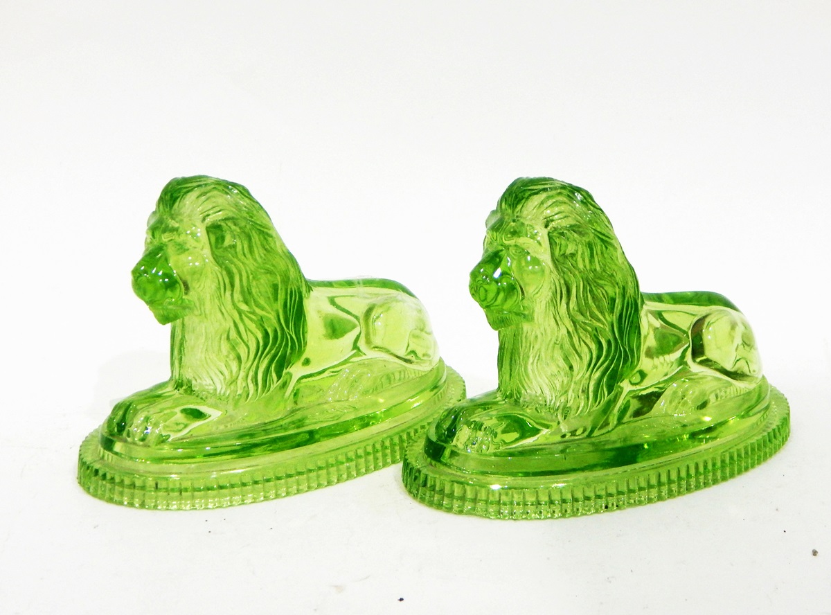 Pair of John Derbyshire green pressed glass lion ornaments, the recumbent lions on oval bases, - Image 2 of 3