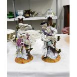 A pair of Dresden porcelain table candlesticks, modelled with a shepherd and shepherdess with sheep,