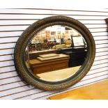 An oval wall mirror in a moulded gilt frame with oval plate,