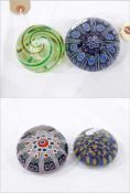 Three glass paperweights, with millefiori cane designs and a Cowdy glass paperweight,