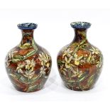 Pair of Royal Doulton Lambeth faience vases of baluster form with mottled brown ground and having