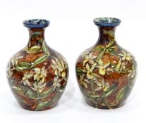 Pair of Royal Doulton Lambeth faience vases of baluster form with mottled brown ground and having