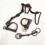 Forged iron manacles and a snaffle bit for a horse