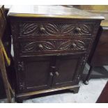 Carved oak cupboard with two long drawers, pair of panel doors below, raised on bracket feet,