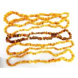 Four strings of yellow amber nugget beads and another amber nugget necklace