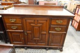 Late Victorian panelled oak side cupboard, the central moulded front door enclosing two shelves,