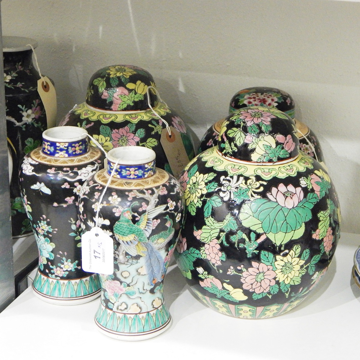 Pair of famille noir ginger jars and covers with allover floral decoration,