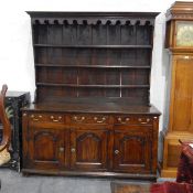 Georgian oak dresser with plate rack, having moulded cornice and carved frieze with three shelves,