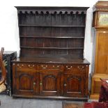 Georgian oak dresser with plate rack, having moulded cornice and carved frieze with three shelves,