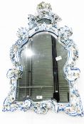 Meissen style porcelain wall mirror in the shape of a shield, with floral and scroll decoration,