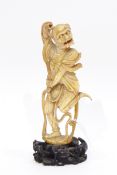 Late 19th century Chinese carved ivory figure of a dancing oni, on carved wooden base,