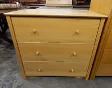 Contemporary pale beech chest of three long drawers, with elegant turned wooden handles,