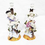 A pair of Dresden porcelain table candlesticks, modelled with a shepherd and shepherdess with sheep,