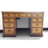 Edwardian oak kneehole pedestal desk having an arrangement of nine drawers with brass bale handles