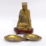 Brass figure of seated mandarin with fly whisk,