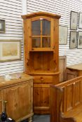 Modern pine corner cupboard, the glazed upper section enclosing shelf with open cupboard below,