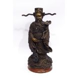 Bronze Chinese robed figure holding a rui sceptre, the base modelled as a dragon, 30cm high,