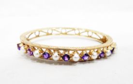 Gold hinged bangle set with 15 alternating round mixed cut amethysts and split pearls,