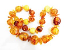 String of yellow and orange polished amber beads of irregular form
