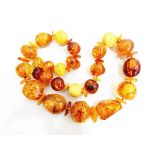 String of yellow and orange polished amber beads of irregular form