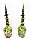 Pair of green ground Bohemian ring neck decanters, having tall tapered stoppers,