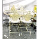 Cream painted metal table and four chairs, with open latticework design,