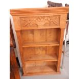Pine three-tier open bookcase having carved panel with vase and flowers,