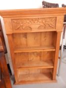 Pine three-tier open bookcase having carved panel with vase and flowers,