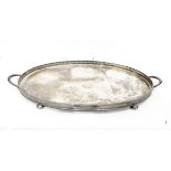 Silver-plated two-handled tray of oval form with pierced gallery on four bun feet,