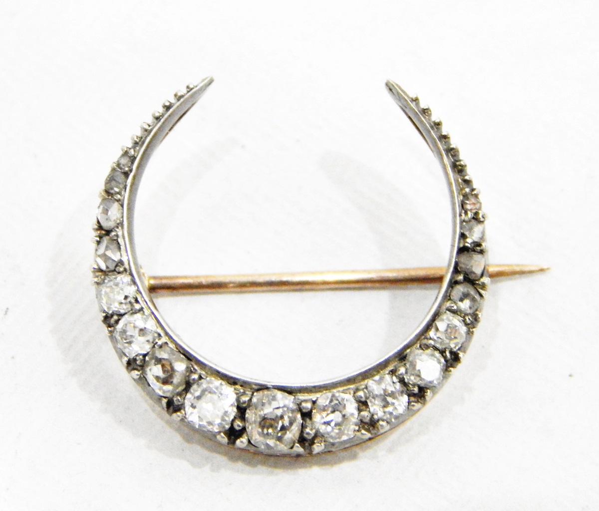 Diamond crescent brooch in white and yellow gold-coloured metal setting,
