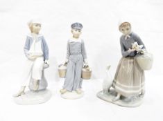 Three Lladro figure groups, one of a girl with ducklings in a basket, 23cm high,