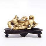 Late 19th/early 20th century Japanese carved ivory model of a dog fighting a serpent,