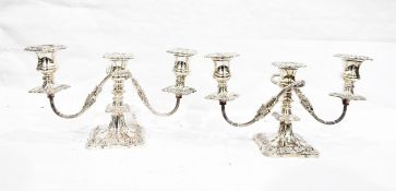 Pair of silver-plated two-branch candelabra with scroll supports on shaped square bases decorated